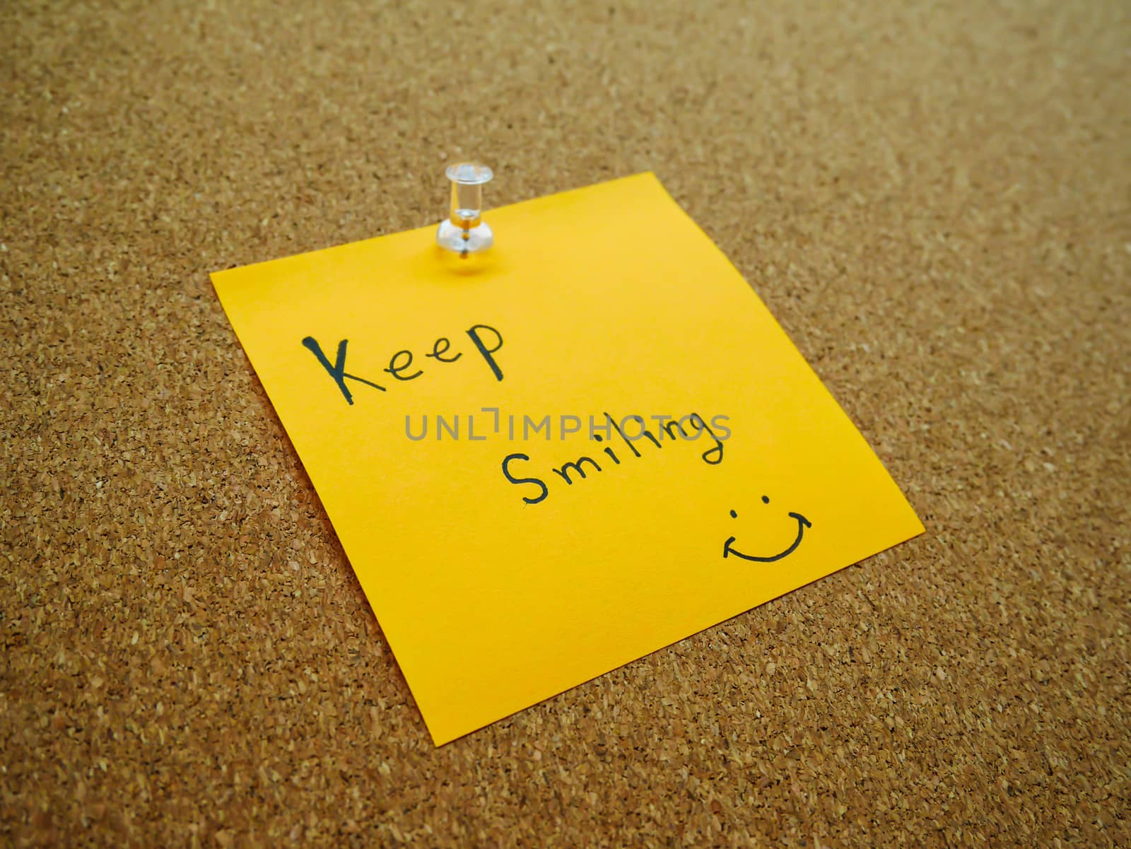 Keep smiling in post note on wooden board