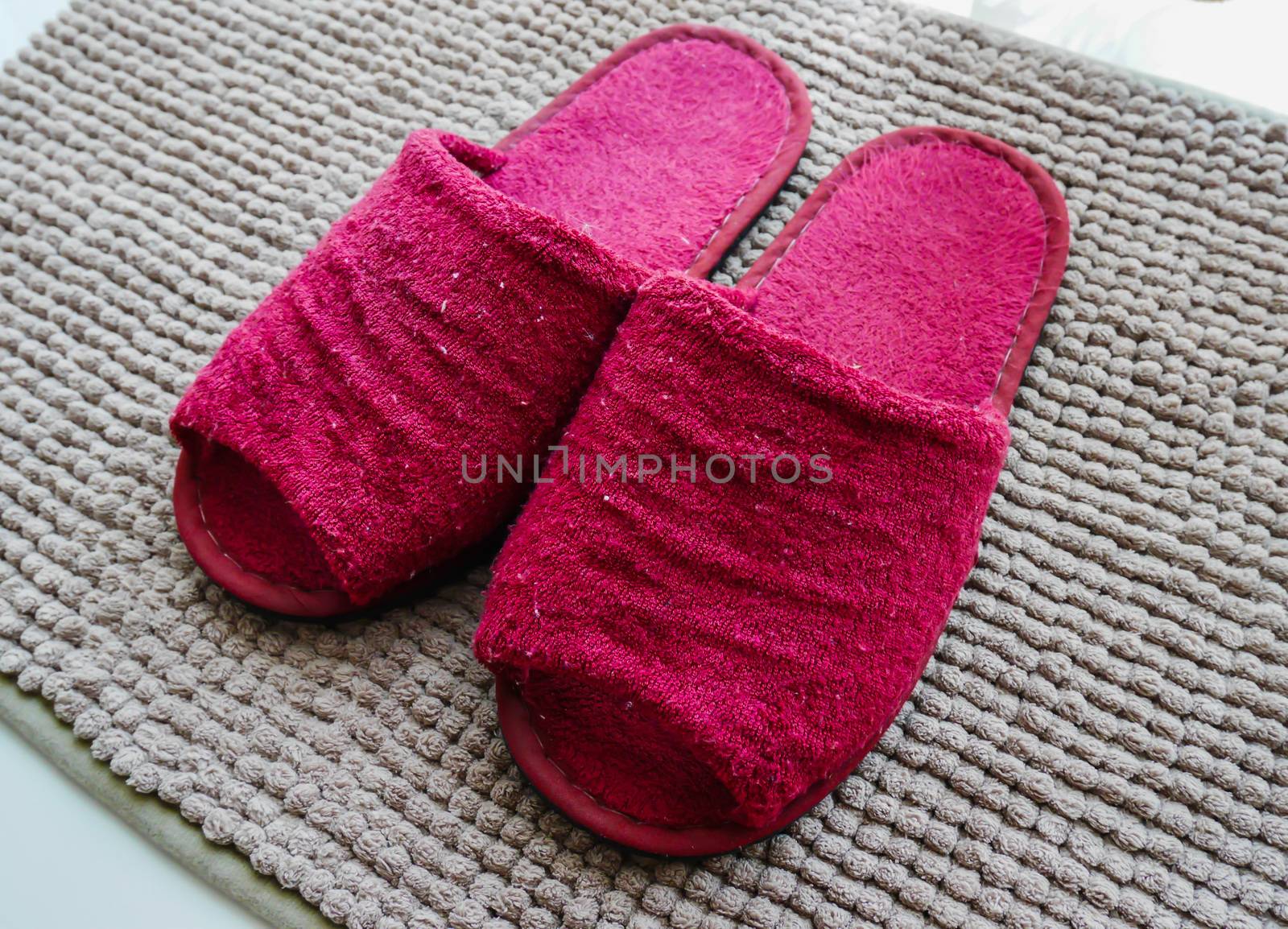 Red slipper on brown carpet 