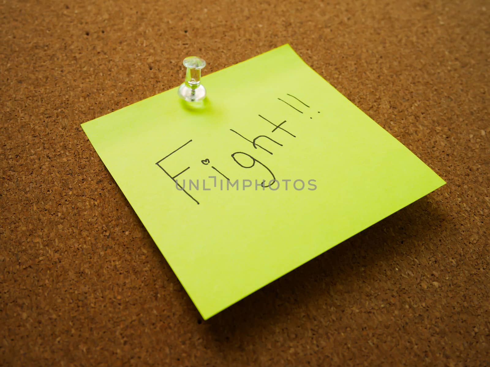 Text fight in green post note and pin on wood board