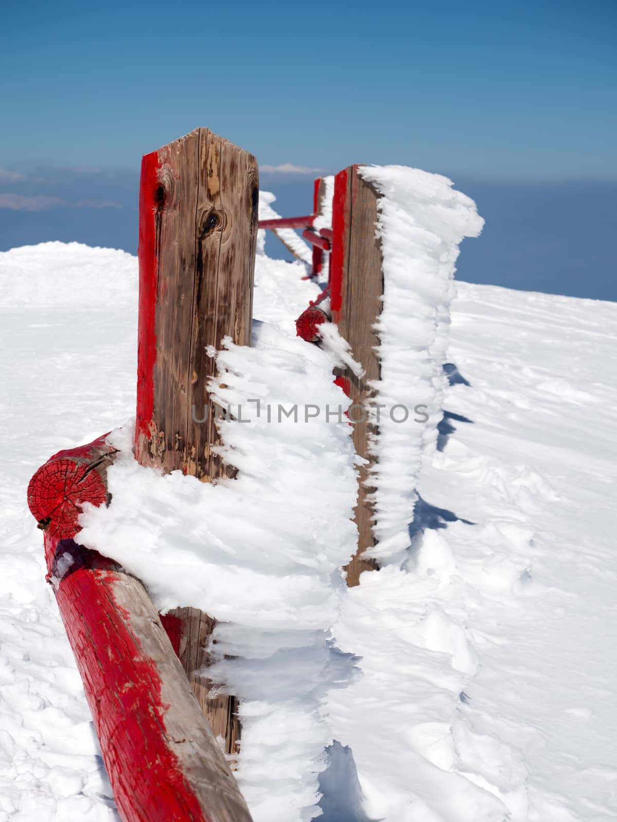 Red frozen fence at  the top of the mountain Helmos in Kalavrita ski resort in a sunny day