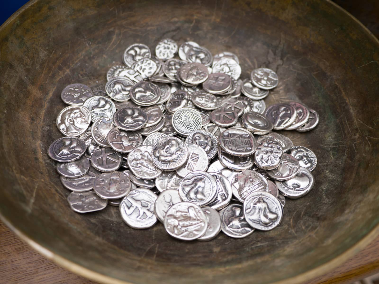 Close up of replica old silver coins in a pot as souvenirs 