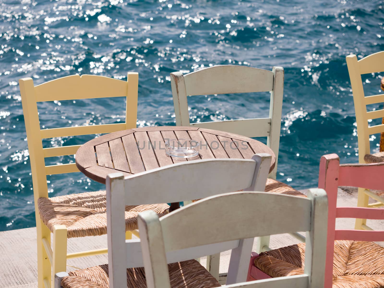 Close up of a wooden table and chairs by the sea