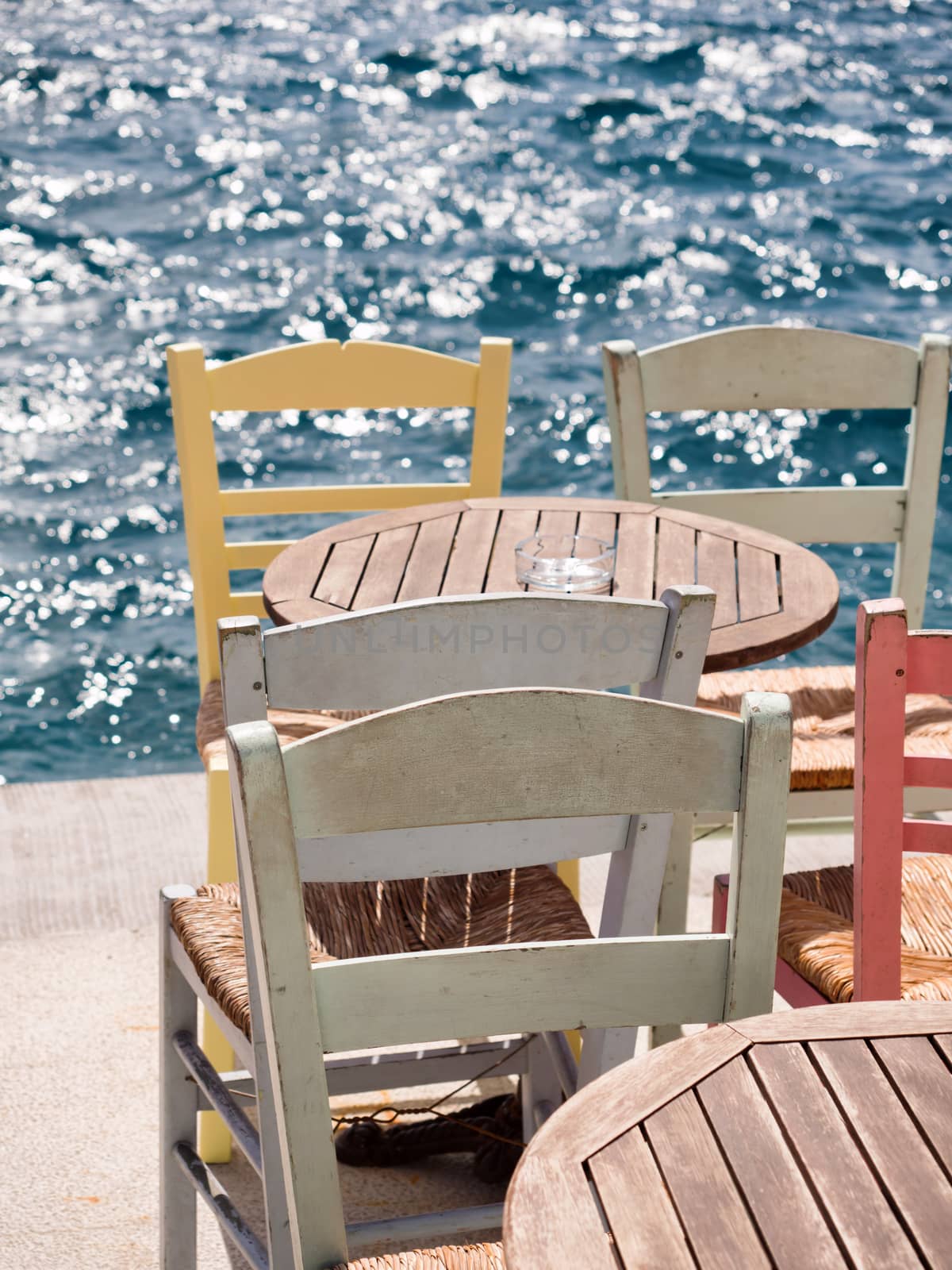 Close up of a wooden table and chairs by the sea