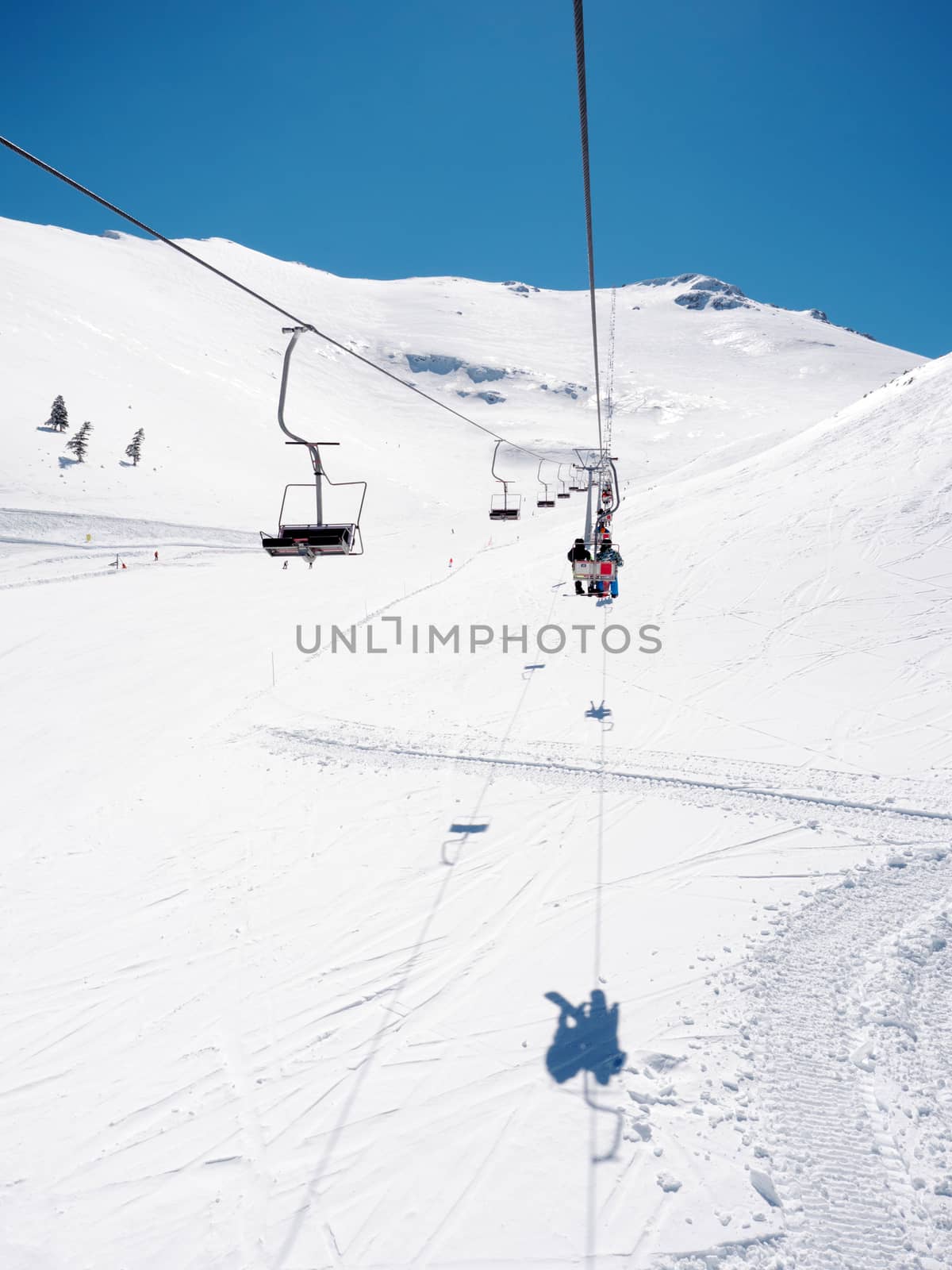 View from the lift of Kalavrita ski resort with people on the slopes in a sunny day
