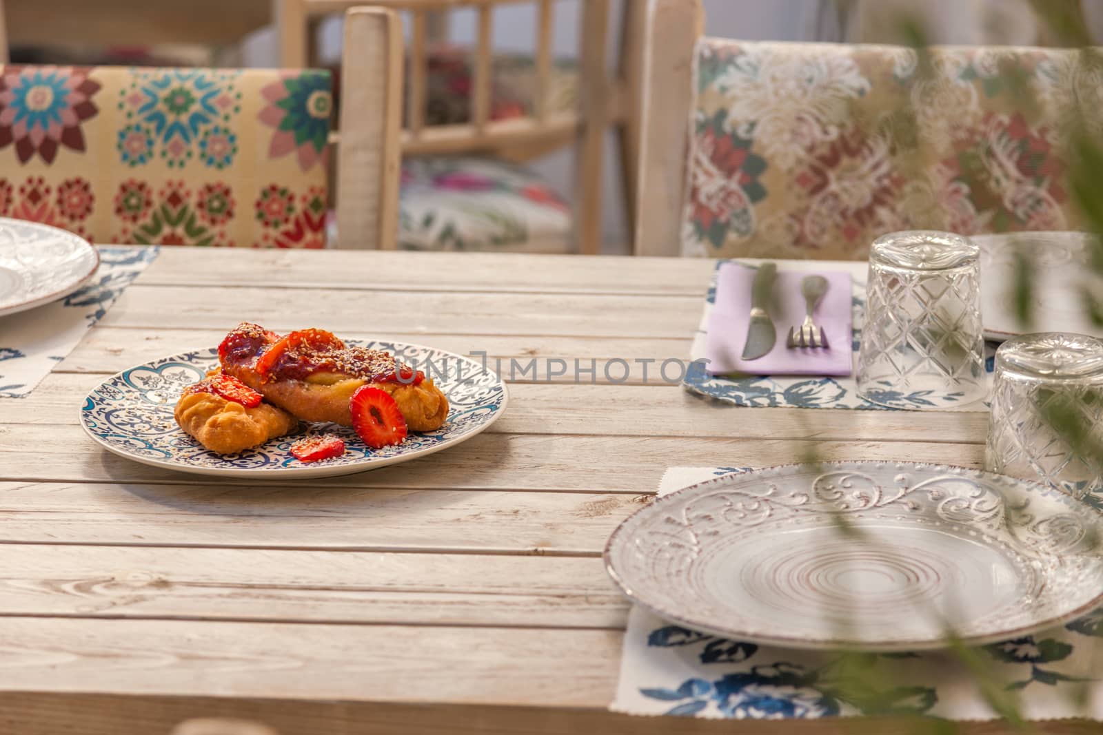 Gourmet greek cheese pie with tomato marmelade and strawberries served on a plate with pattern
