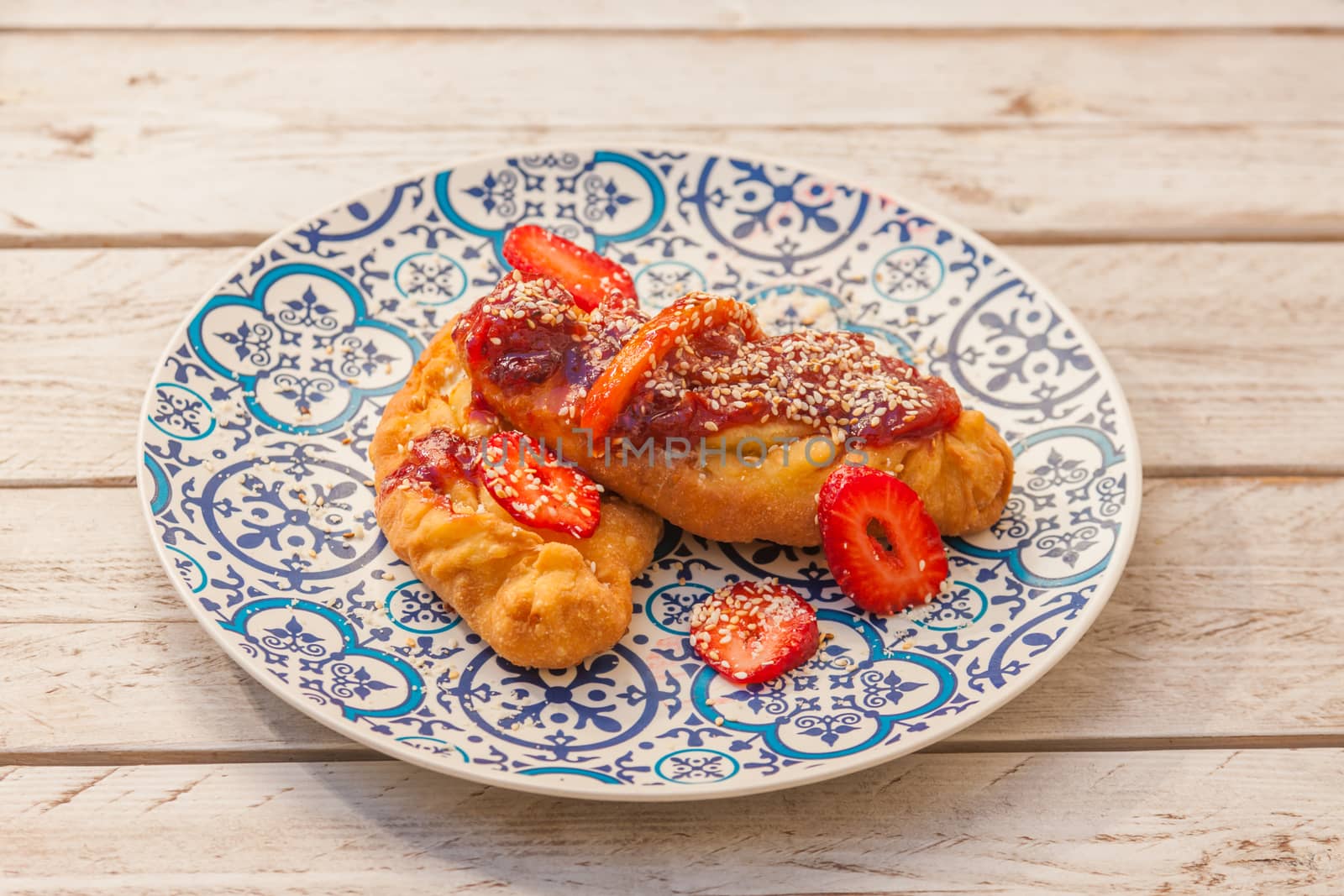 Gourmet greek cheese pie with tomato marmelade and strawberries served on a plate with pattern