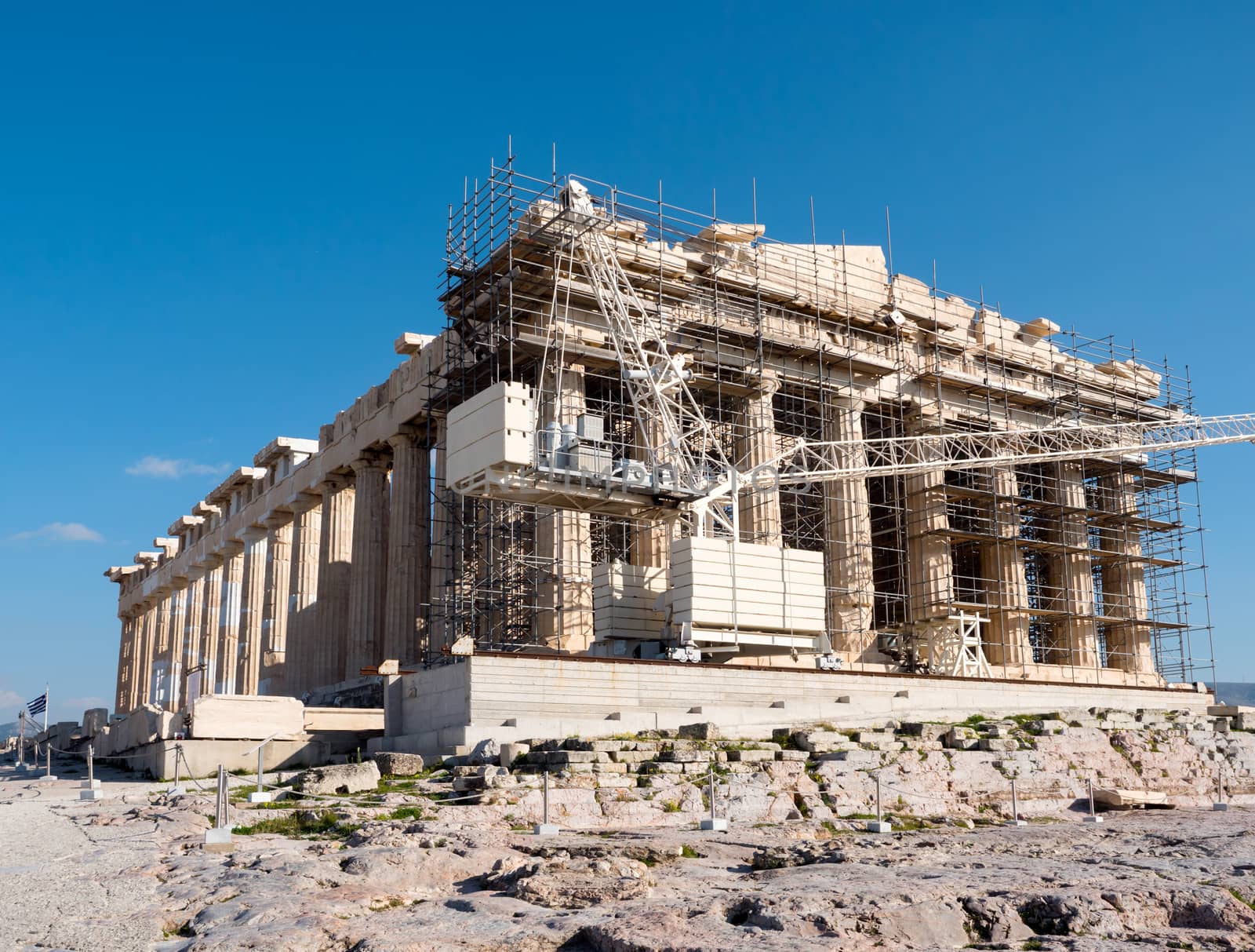 Part of Parthenon temple in Acropolis hill surrounded by scaffolding, Athens, Greece