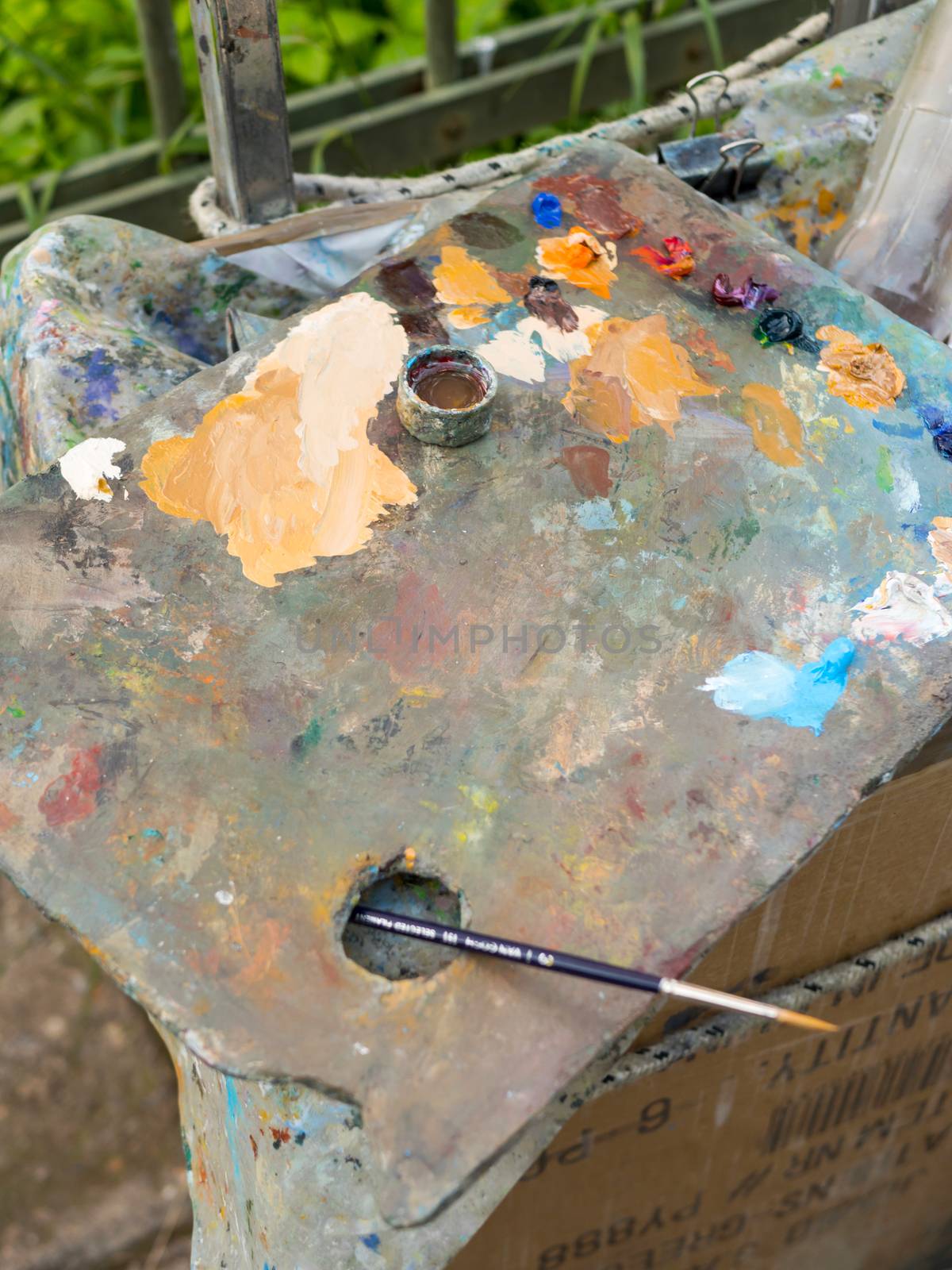 Closeup of a pallette with mixedoil colors and a brush for painting