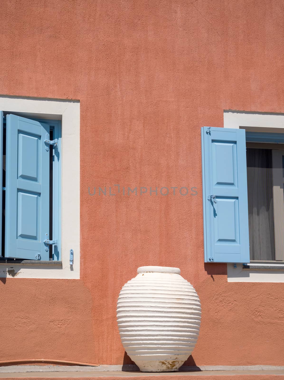 Exterior of a traditional greek house with blue windows and a pot in Assos village, Kefalonia, Ionian Islands, Greece
