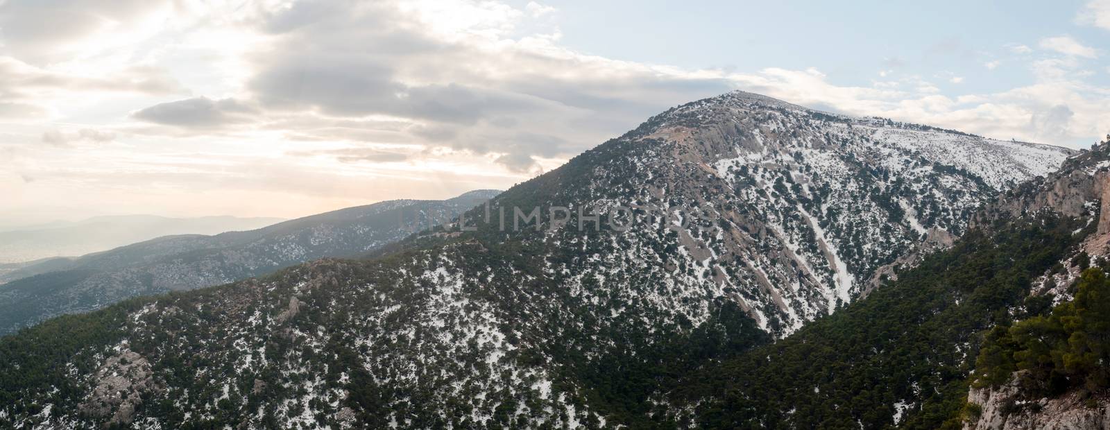 Panoramic view of Parnitha mountain landscape with snow and cloudy sky, Athens, Greece