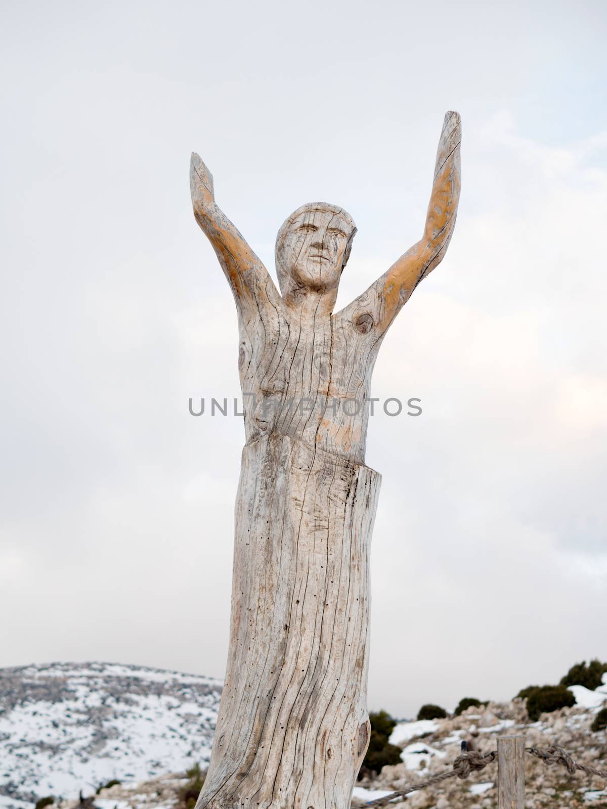 Athens, Greece -  04 January 2017: Wood carving sculptures at the park of lost souls with snow and cloudy sky at Parnitha, Athens, Greece