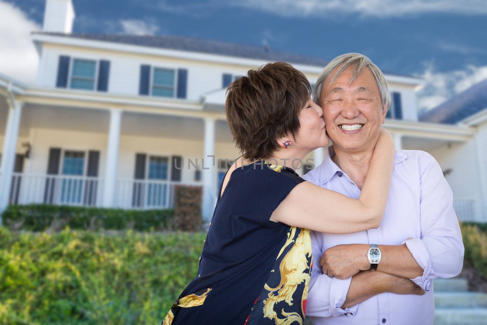 Happy Chinese Senior Adult Couple Kissing In Front Of Custom House. by Feverpitched