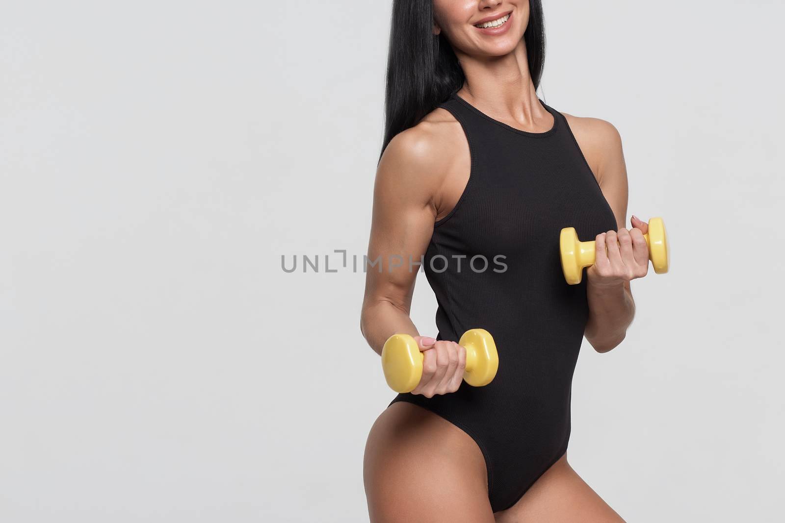 Fitness woman with barbells on grey background by 3KStudio