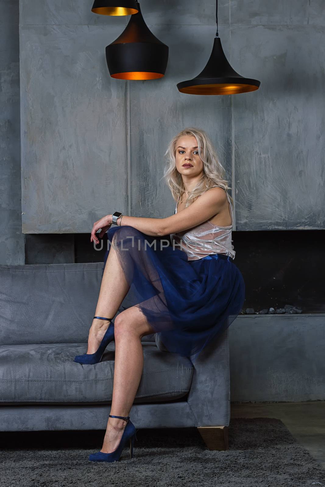 girl sitting on the couch. Room in loft style. Room with a fireplace