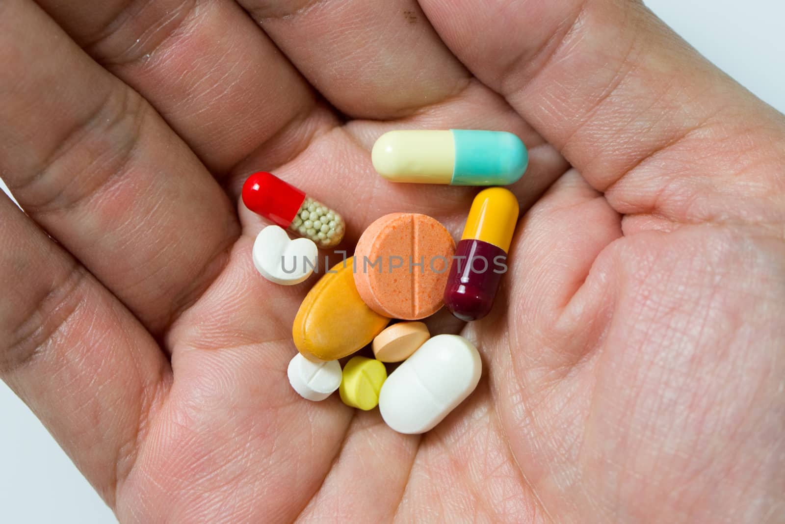 Hand full of large pile of different pills