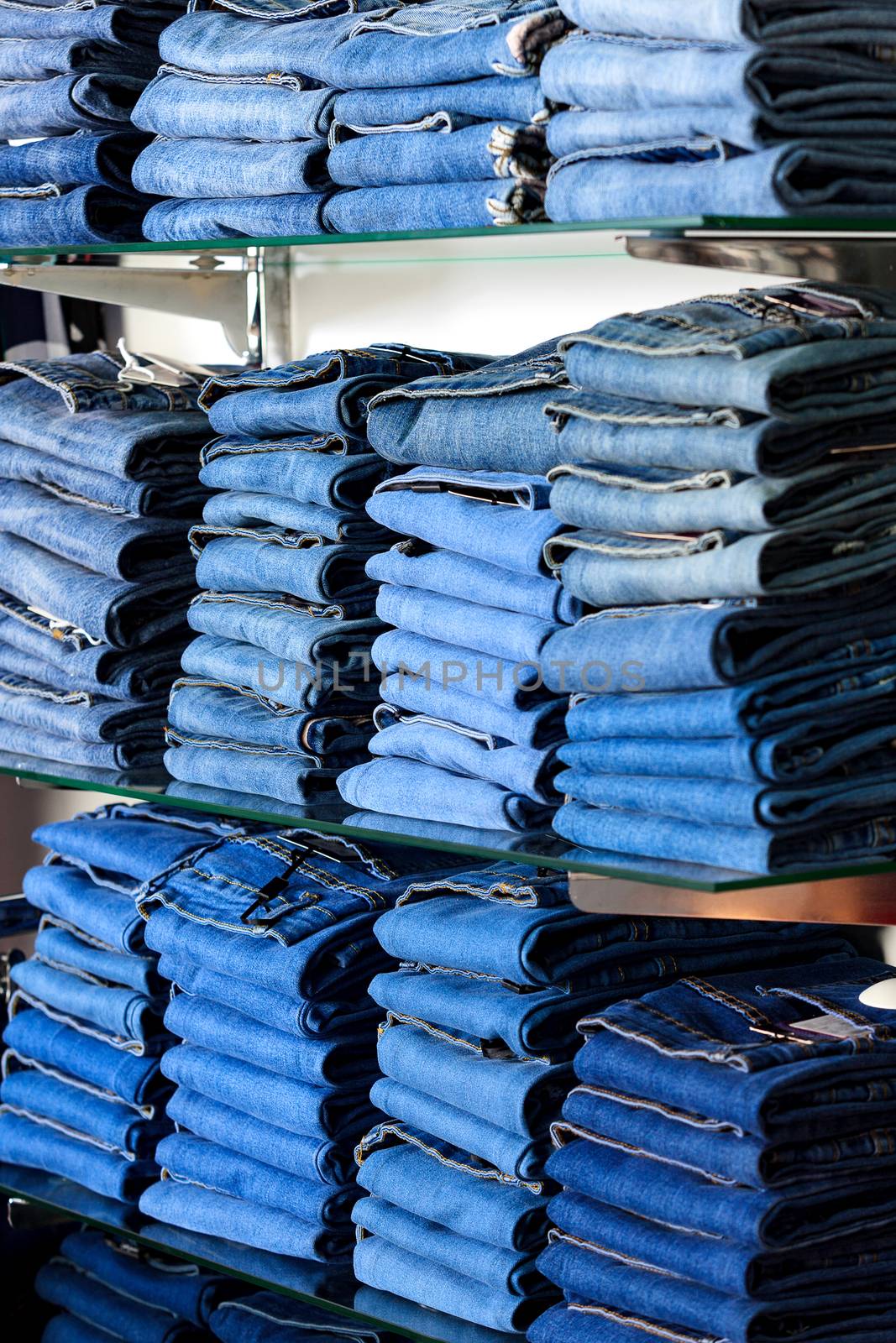 Closeup shot of stack of folded jeans in the fashion store by Nobilior