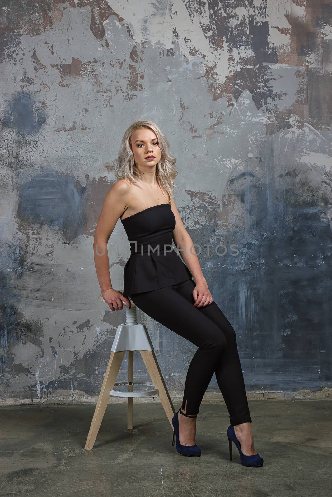 girl ir sitting on a high chair next to a wall by victosha