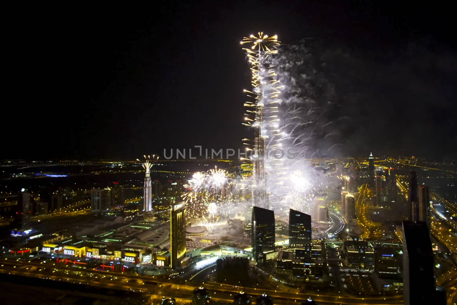 Festive firework in Dubai. Beautiful colorful holiday fireworks in the evening sky with majestic clouds, long exposure