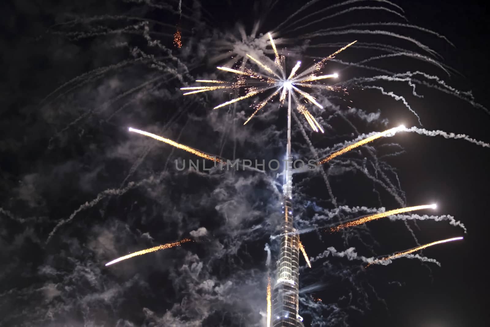Festive firework in Dubai. Beautiful colorful holiday fireworks in the evening sky with majestic clouds, long exposure