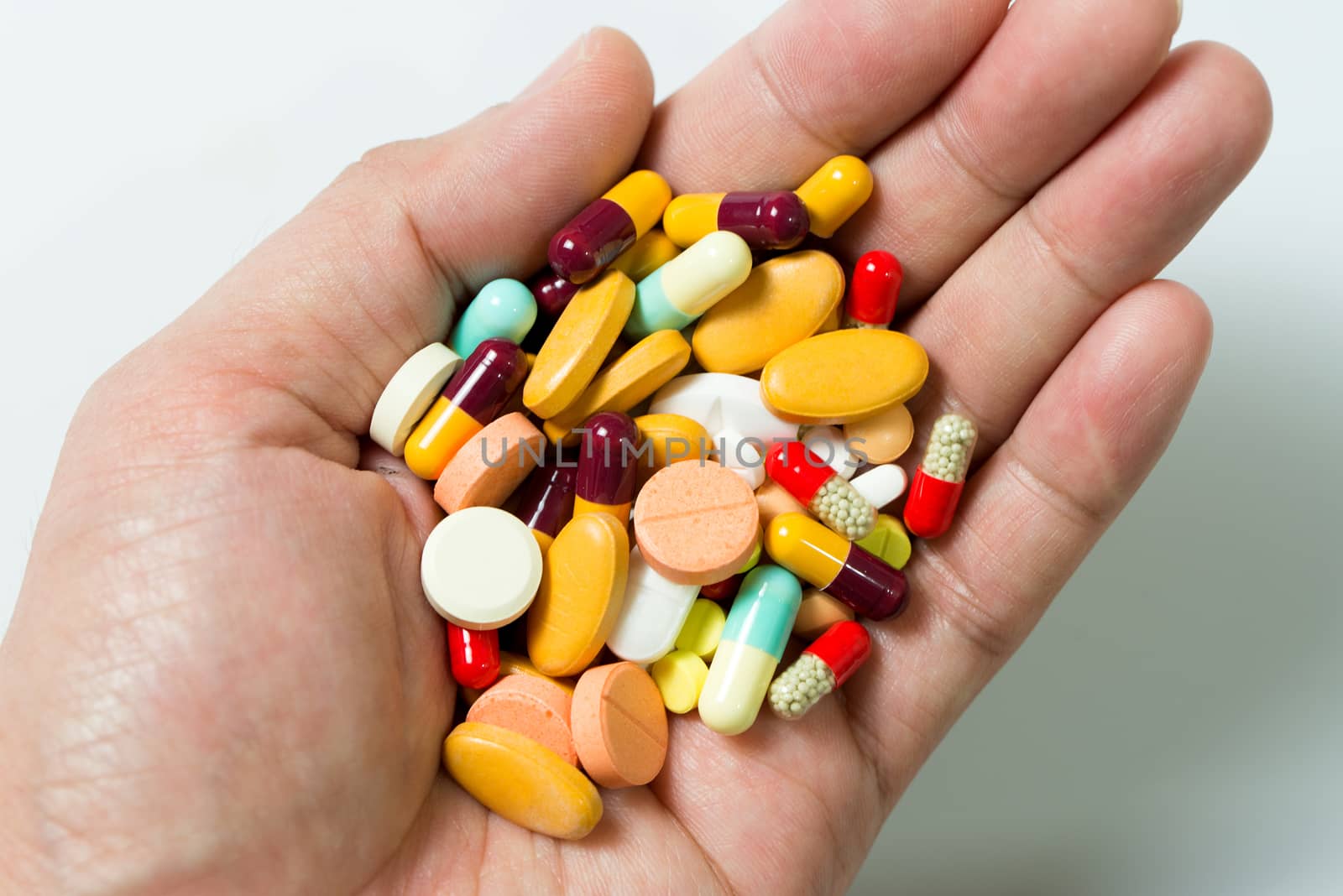 Hand full of large pile of different pills