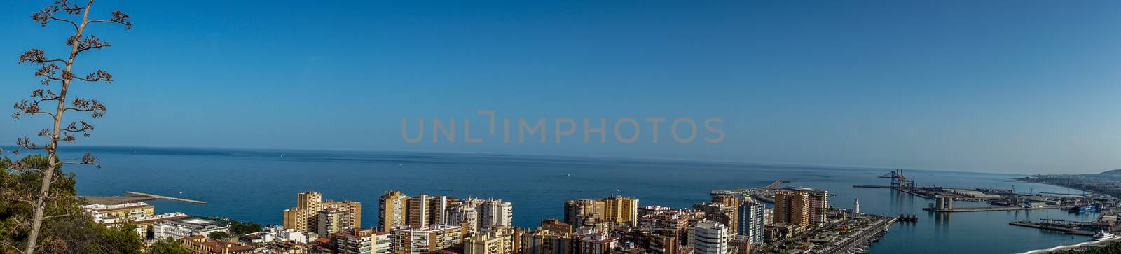 Panorama City skyline and harbour, sea port of Malaga overlooking the sea ocean in Malaga, Spain, Europe  on a summer day with blue sky
