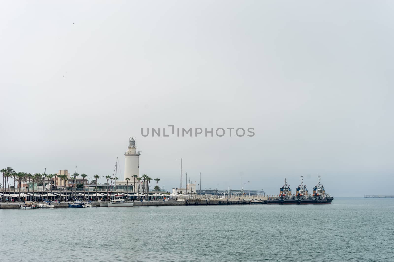 Lighthouse and ships along the coastline at Malaga, Spain, Europ by ramana16