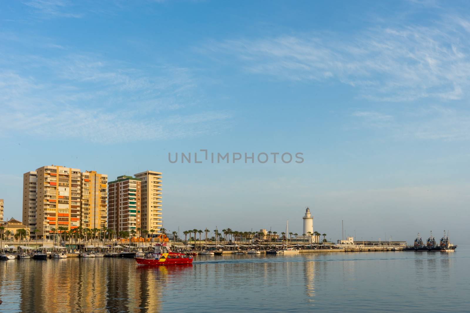 White lighthouse and the tall buildings of Malaga with their ref by ramana16