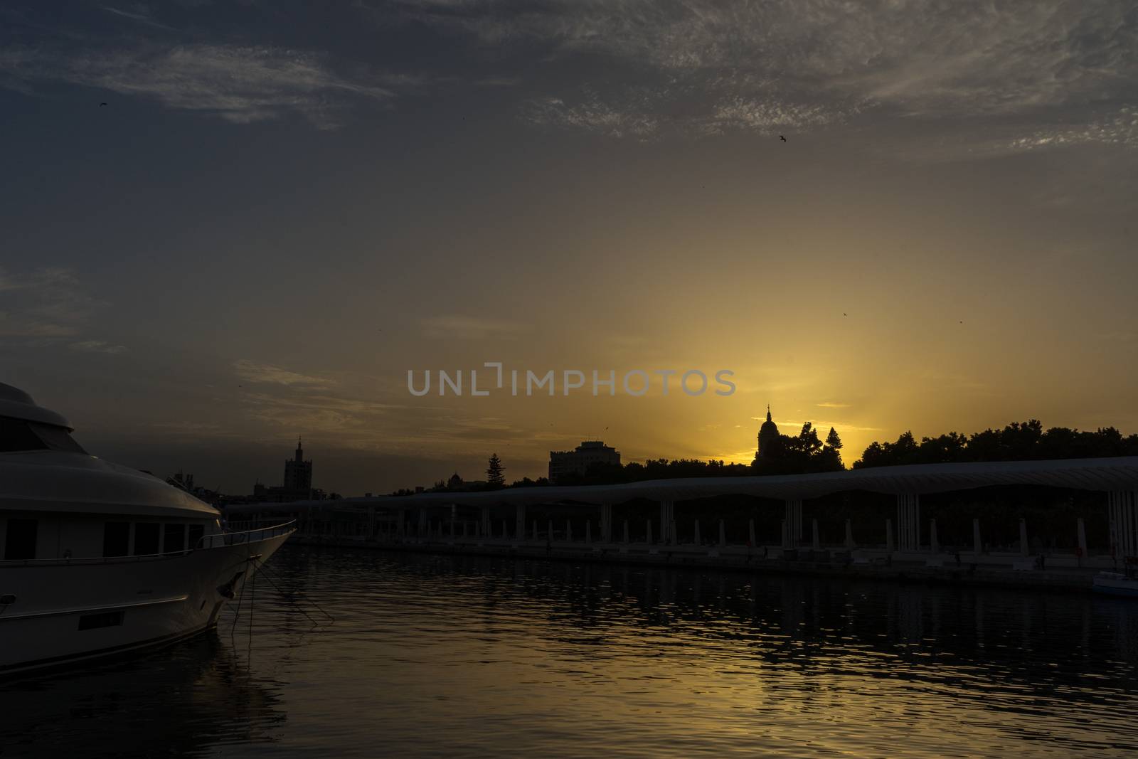 The docking harbour of Malaga with sun set in the background in Malaga, Spain, Europe at the golden hour