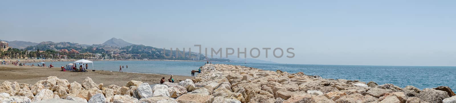 Panoramic view of the ocean at Malagueta beach with rocks at Malaga, Spain, Europe on a clear sky morning