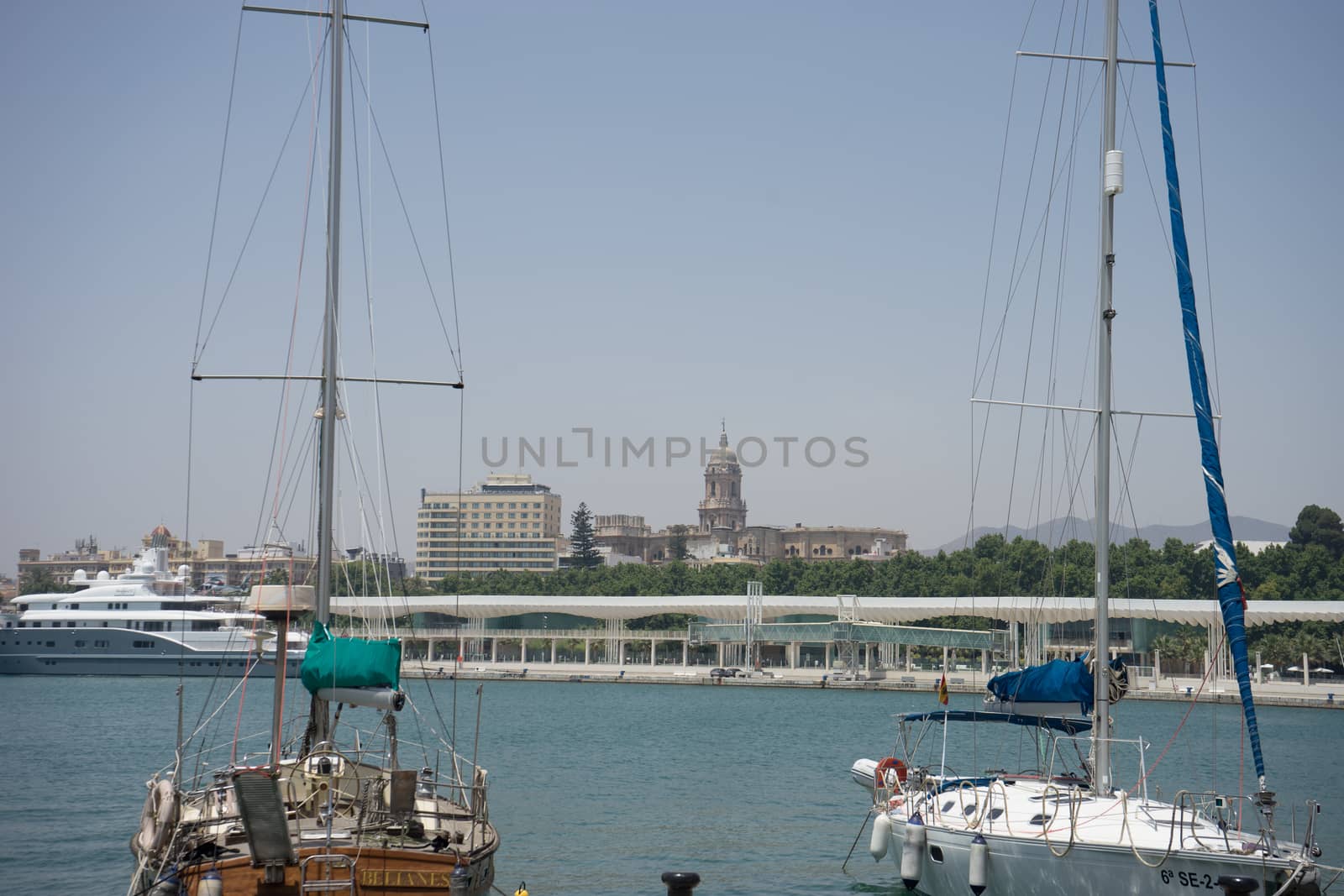 Boats with their sails down docking at the harbour in Malaga, Spain, Europe on a summer day with clear skies