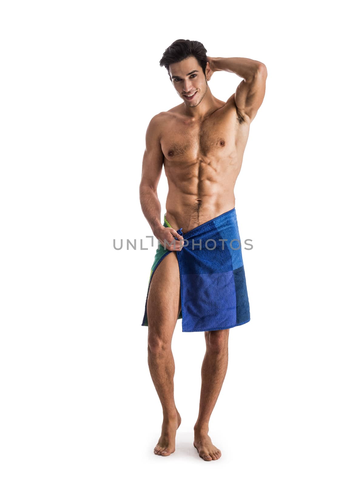 Portrait of naked handsome young man with languishing look covering crotch with a towel, isolated on white background