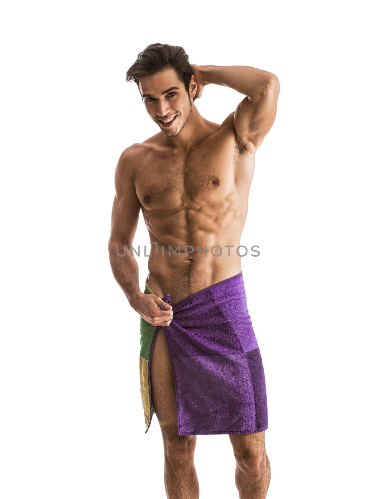 Portrait of naked handsome young man with languishing look covering crotch with a towel, isolated against white background