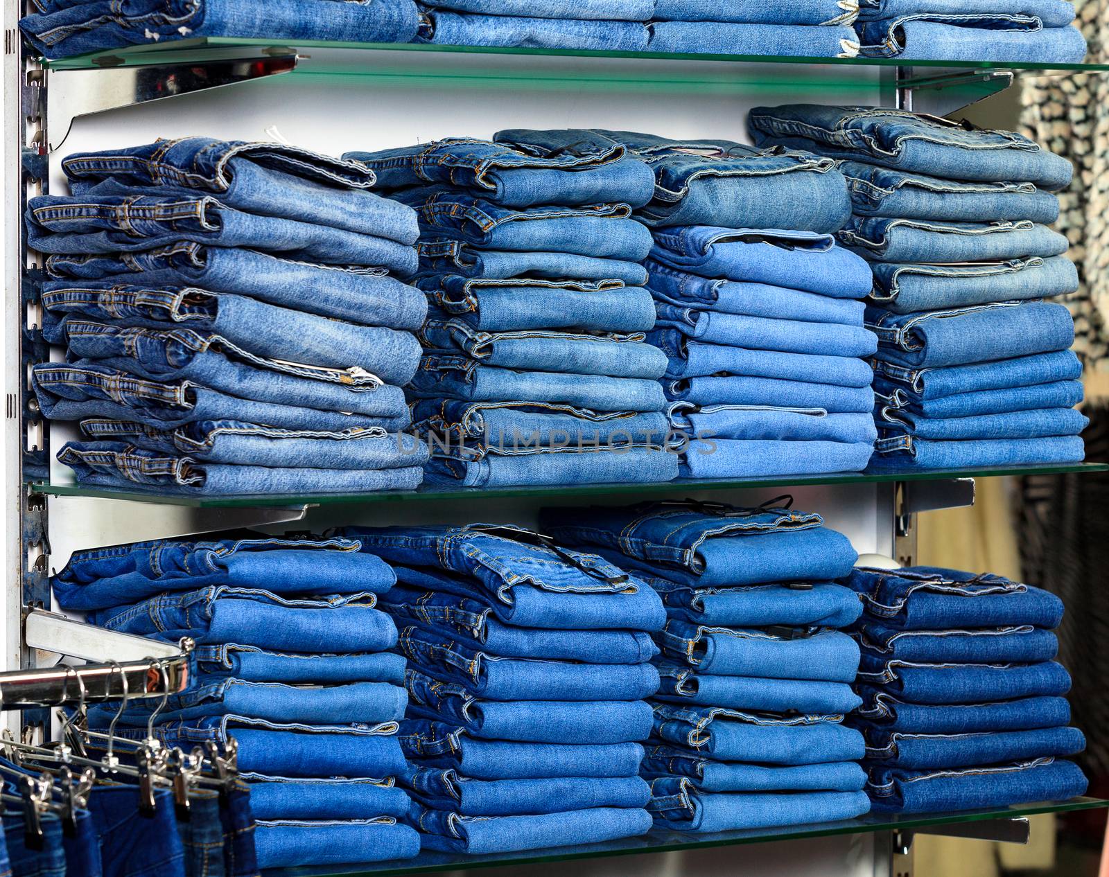 Closeup shot of stack of folded jeans in the fashion store by Nobilior