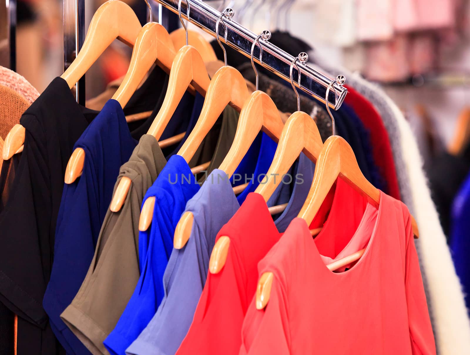 Closeup shot of clothes hang on a shelf in modern fashion store