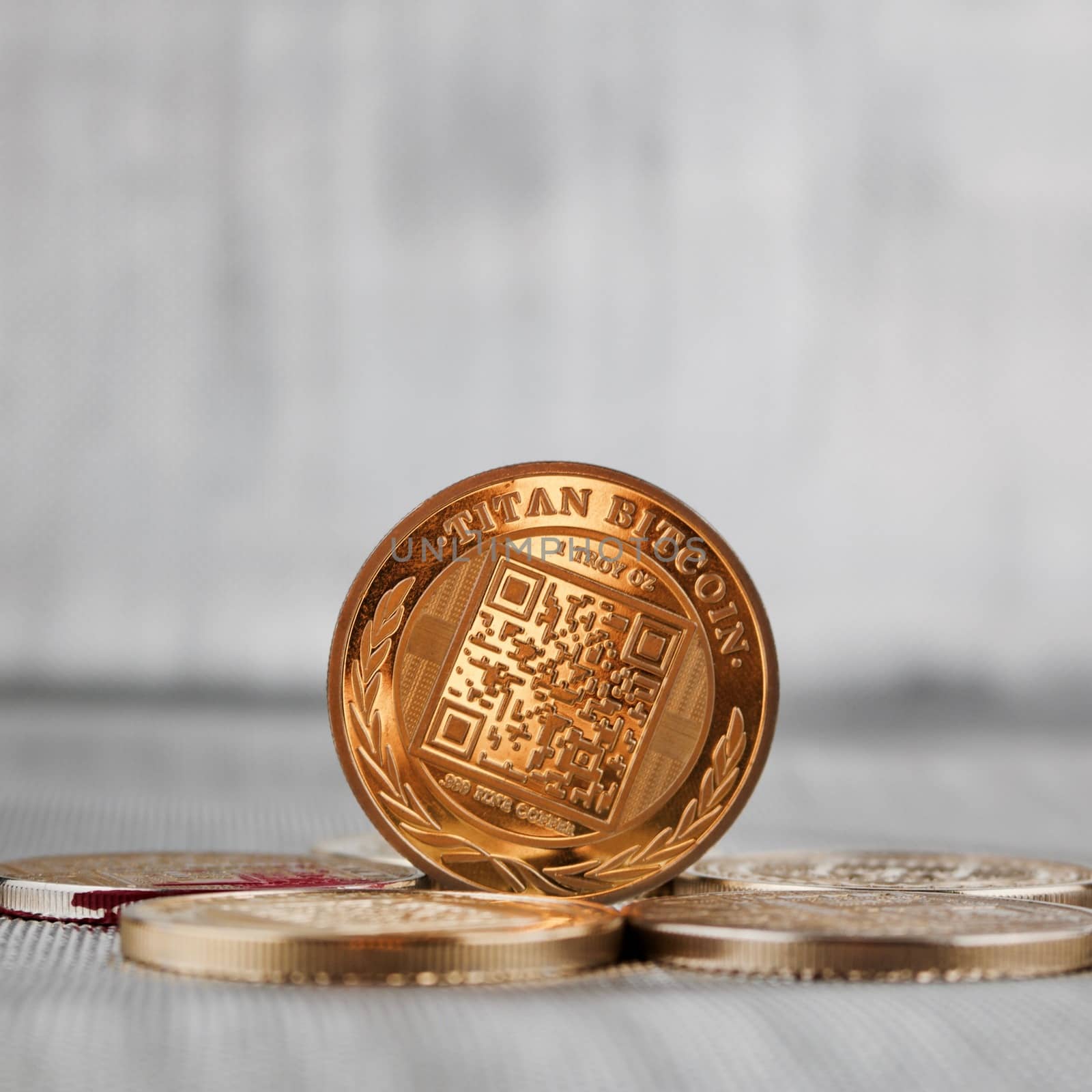Digital currency physical gold titan bitcoin coin on the gold money. Silver background.