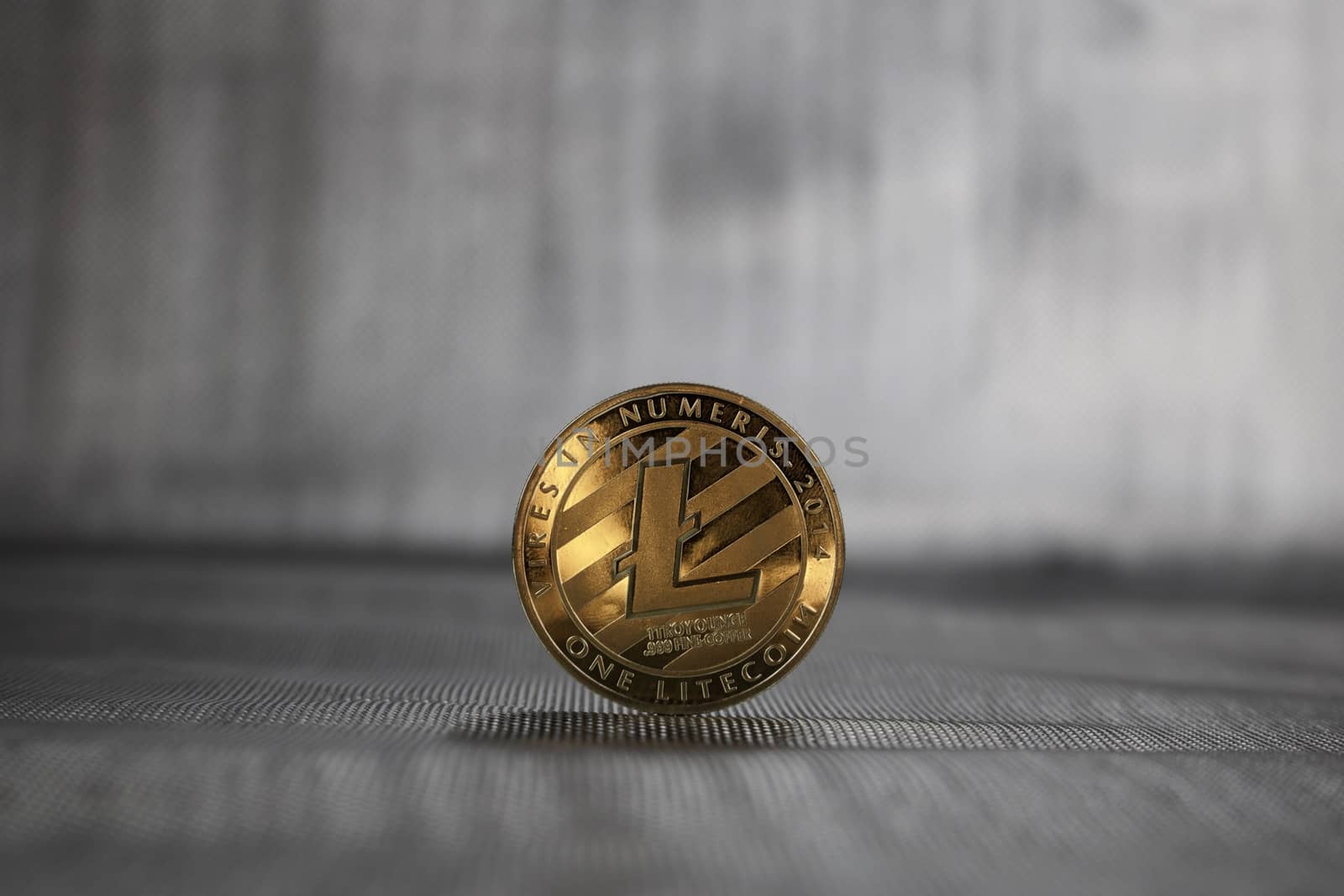 Digital currency physical gold Litecoin coin on the silver background.