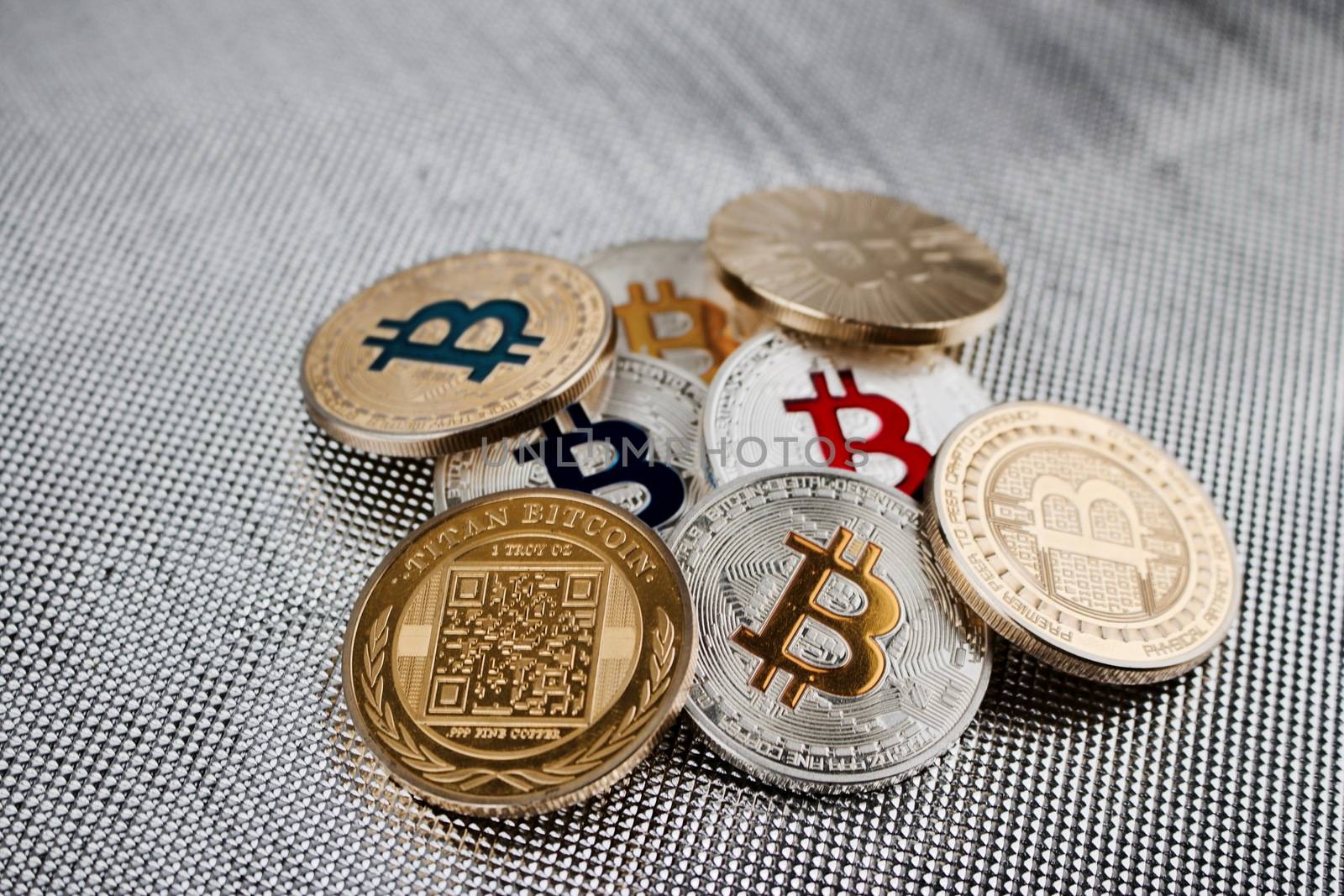 Digital currency physical gold and silver colorful bitcoins on silver background.