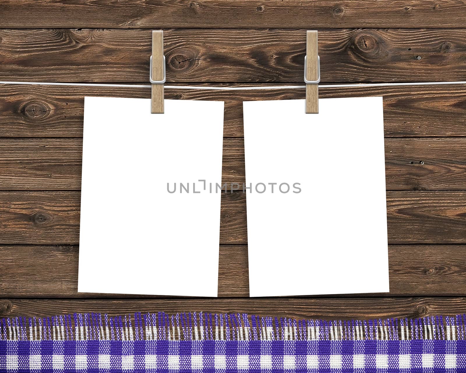 Paper cards hanging on a clothesline with clothespins on wood background