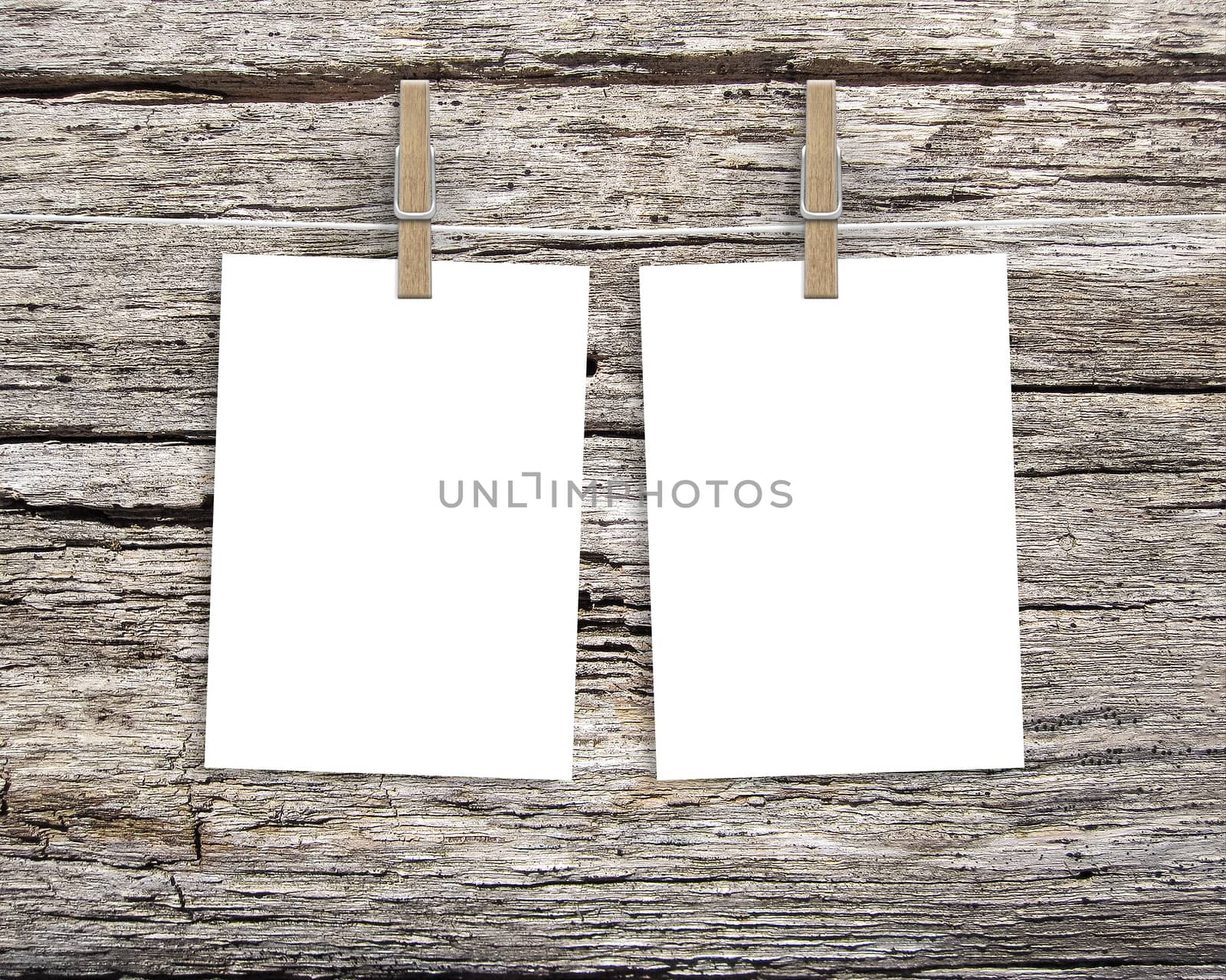 Paper cards hanging on a clothesline with clothespins on wood background by boys1983@mail.ru