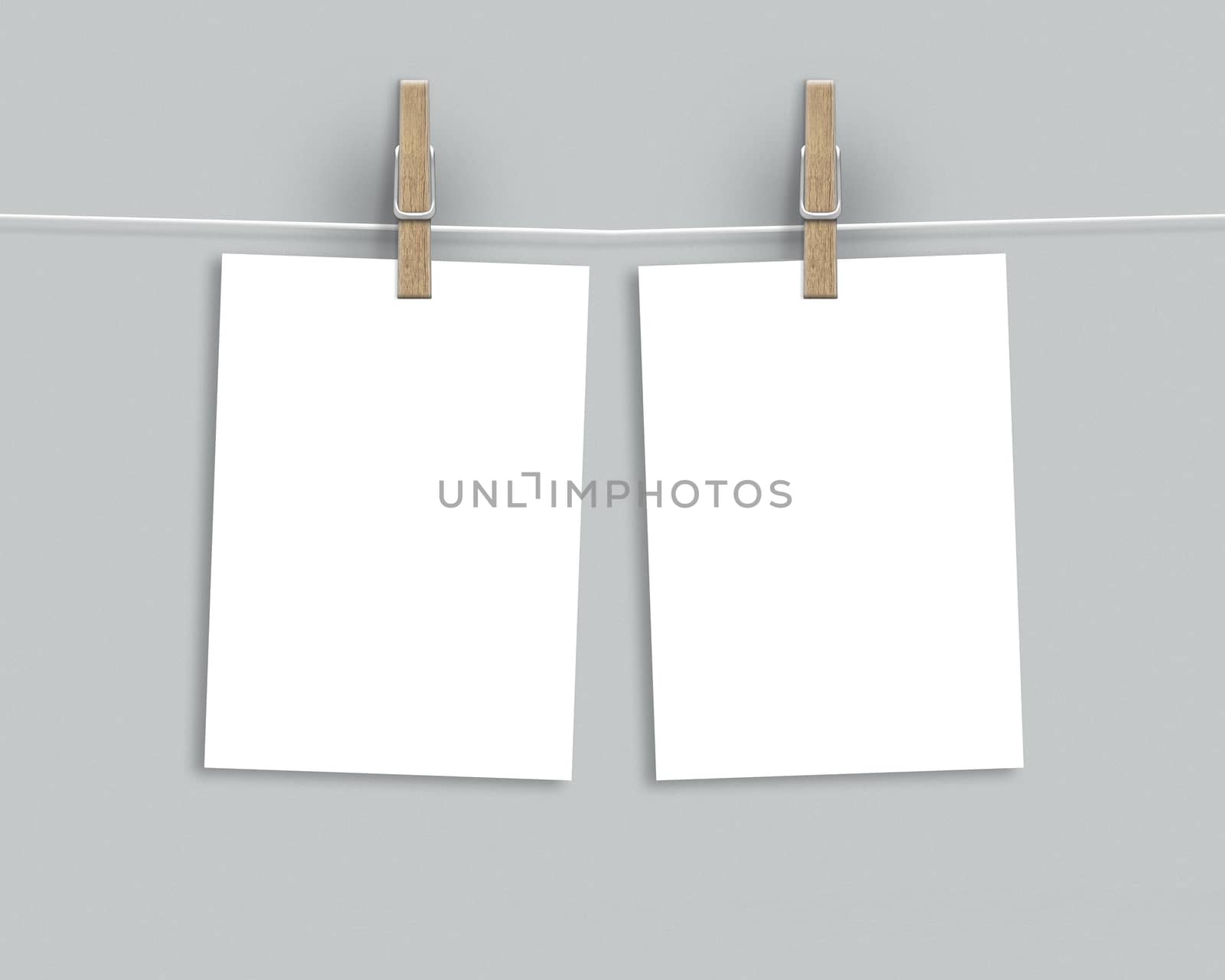 Paper cards hanging on a clothesline with clothespins on light background