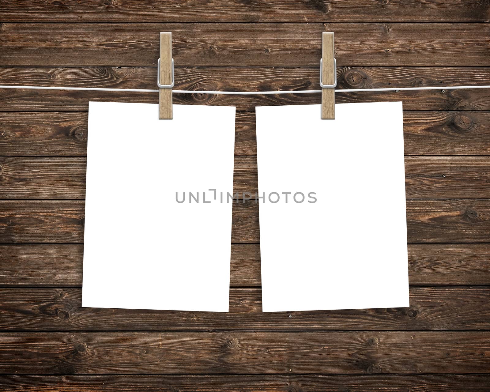 Paper cards hanging on a clothesline with clothespins on wood background