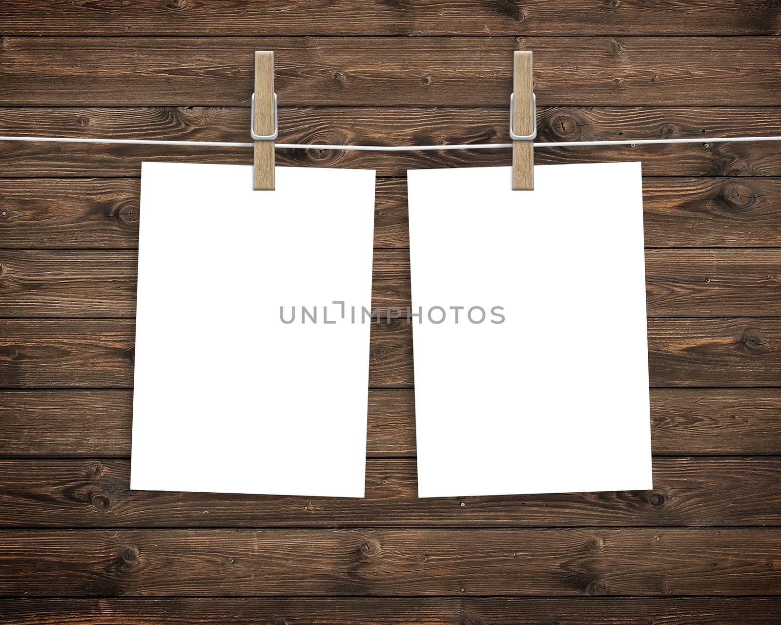 Paper cards hanging on a clothesline with clothespins on wood background