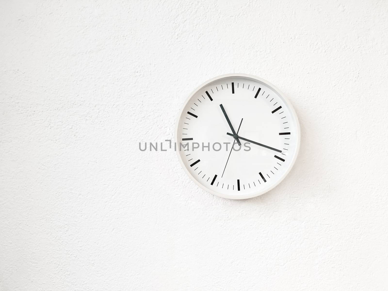 Simple modern round clock on white wall by anikasalsera