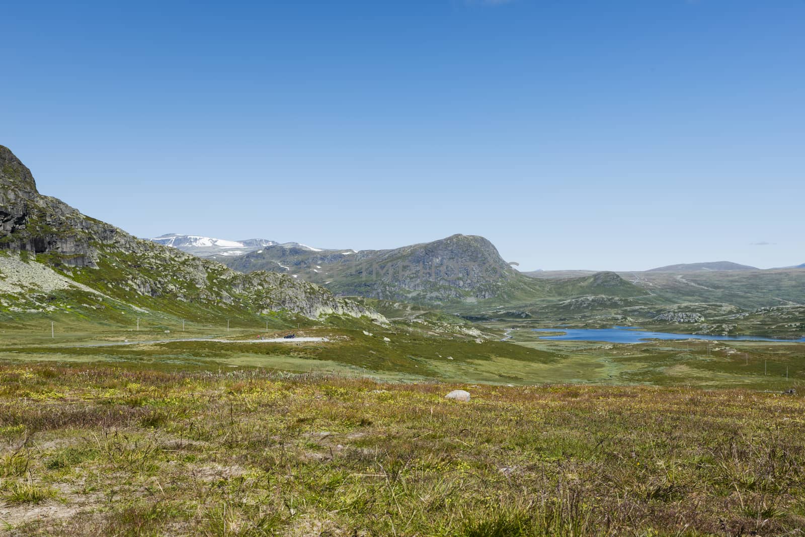 background of green hills and mountains in norway with blue sky background