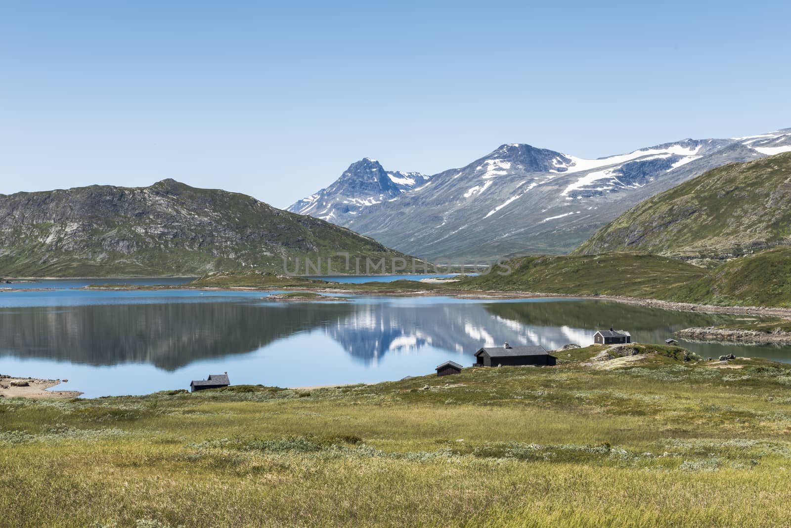 walking track in national park from bitihorn to stavtjedtet with lakes fjord and snow on the mountains