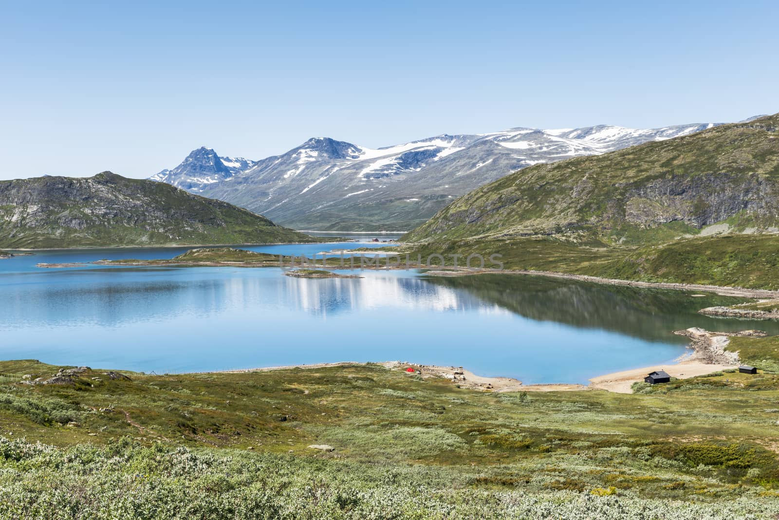 walking track in national park from bitihorn to stavtjedtet with lakes fjord and snow on the mountains