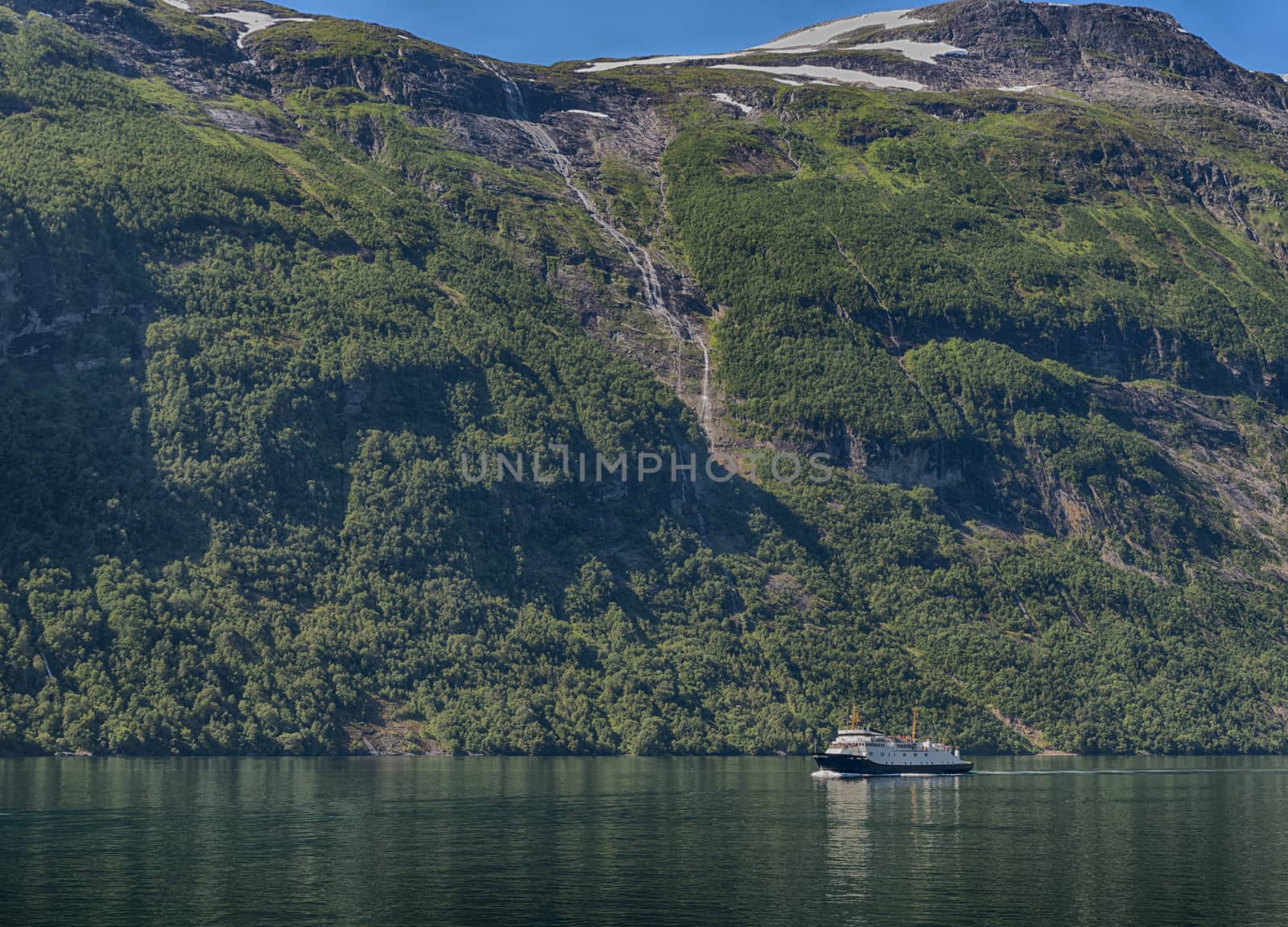 people on cruise boat at the famous geiranger fjord waterfalls in norway