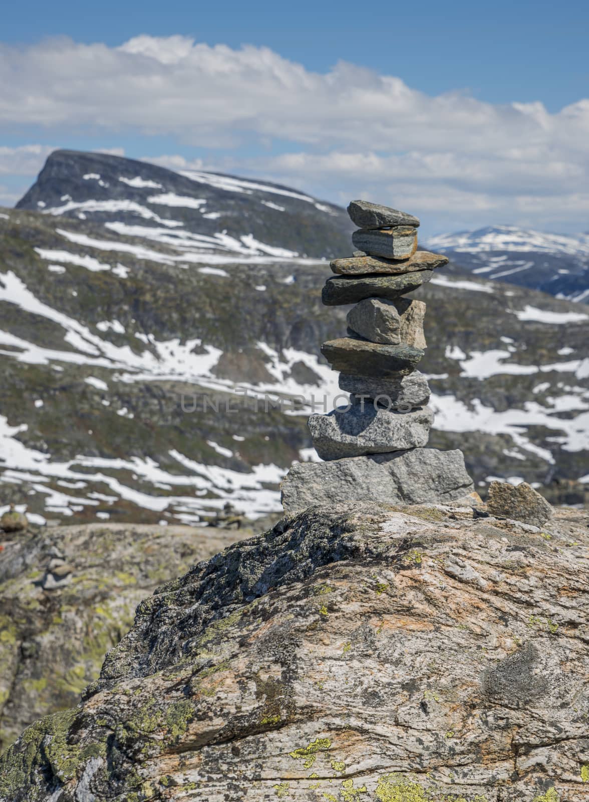 balanced stack of stones at dalsnibba with the mountains and snow as background
