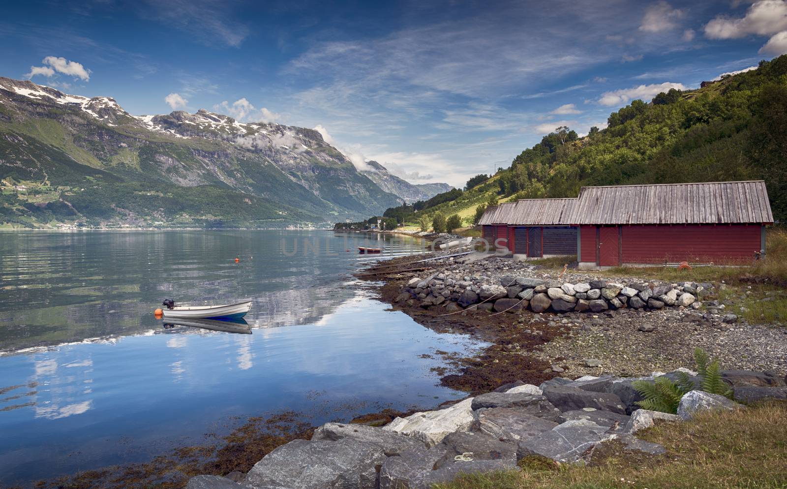 red houses and a boat in the fjord in norway by compuinfoto