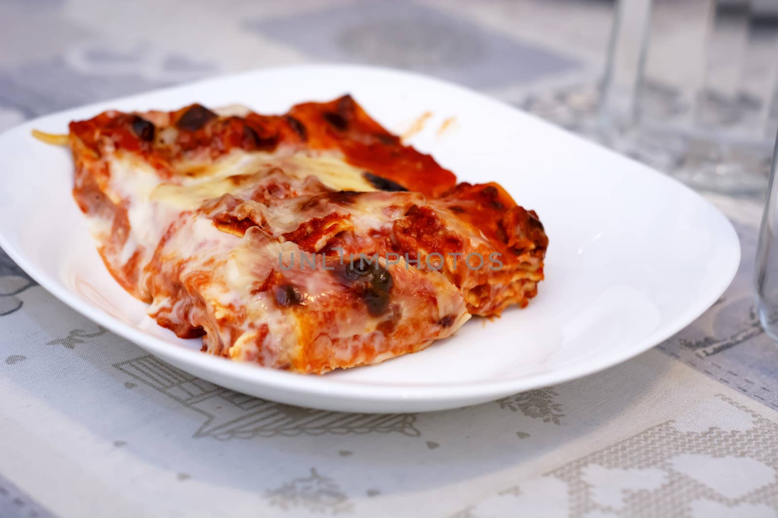 close-up view of a portion of lasagna served on a white plate